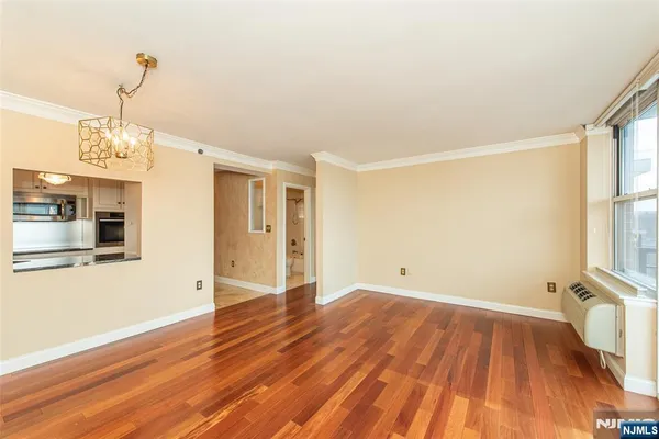 a view of a big room with wooden floor and windows