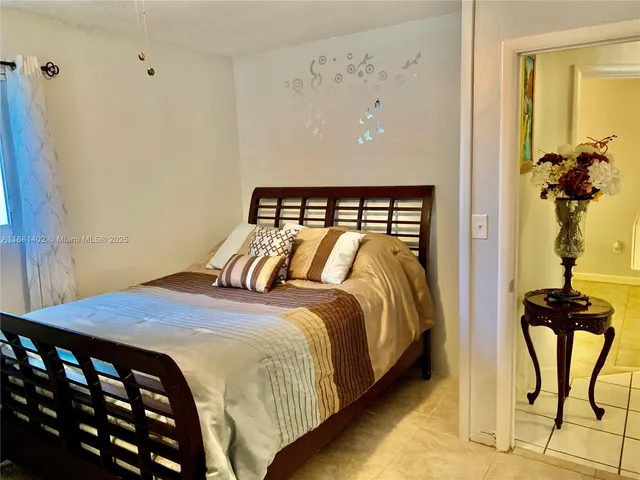 a bedroom with a bed and dresser with mirror