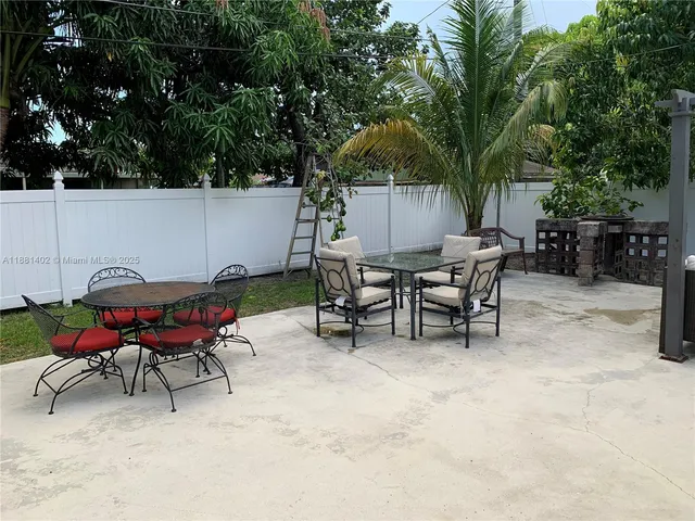 a backyard of a house with table and chairs