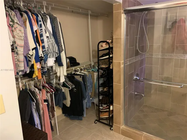 a view of walk in closet with clothes