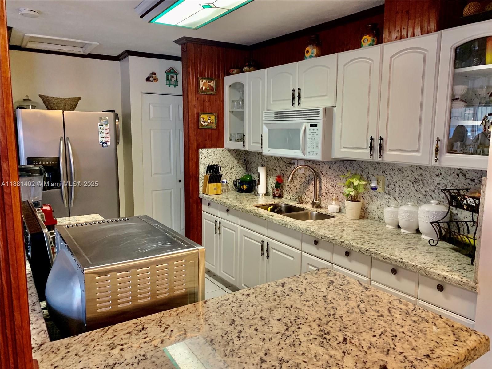 6180 Southwest 42nd Court Davie, FL 33314 - Photo 8 of 25 a kitchen with stainless steel appliances granite countertop a sink stove and refrigerator
