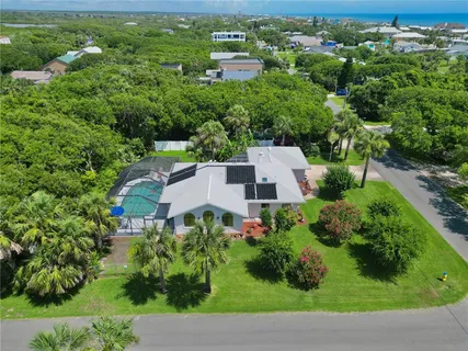 an aerial view of residential houses with outdoor space and trees