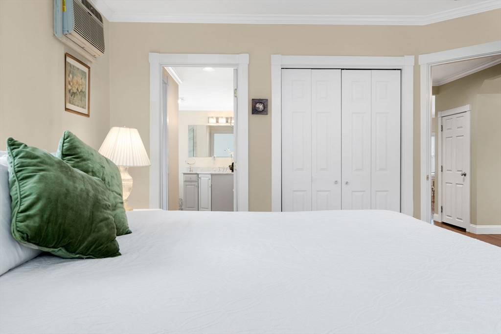 20 Ash Street, Unit 1 Danvers, MA 01923 - Photo 28 of 42 a bedroom with a bed and a mirror