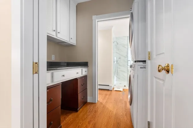 a view of a white house with a yard and plants next to road