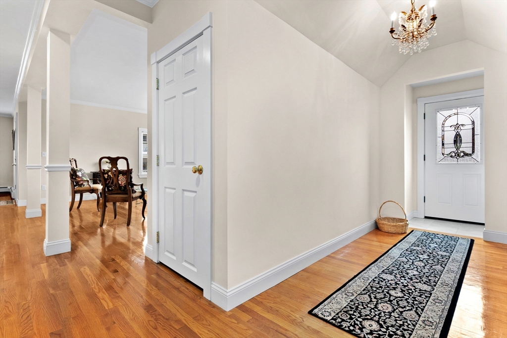 20 Ash Street, Unit 1 Danvers, MA 01923 - Photo 9 of 42 a room with wooden floor and a chandelier