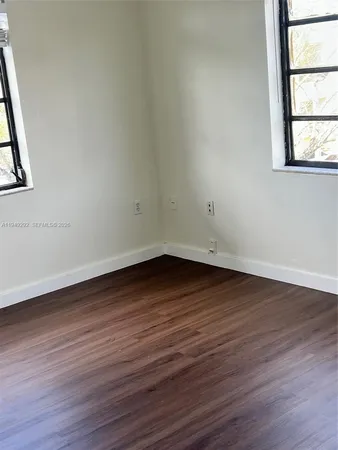 a view of a hallway with wooden floor and closet