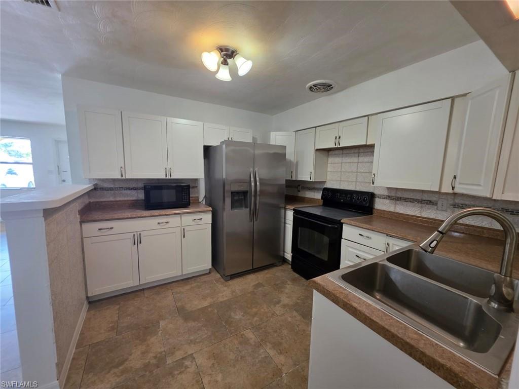 2103 Unity Avenue Fort Myers, FL 33901 - Photo 15 of 40 a kitchen with a refrigerator stove and sink