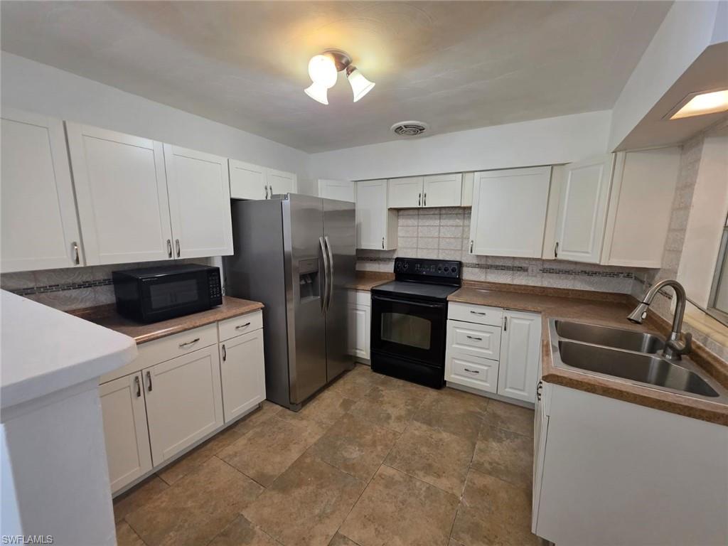 2103 Unity Avenue Fort Myers, FL 33901 - Photo 2 of 40 a kitchen with a refrigerator stove and sink