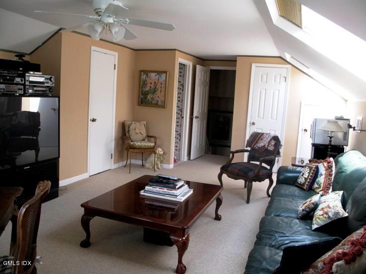 13 Georgetowne North, Unit 13 Greenwich, CT 06831 - Photo 12 of 17 a living room with furniture and a chandelier