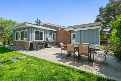 a view of a house with backyard and sitting area