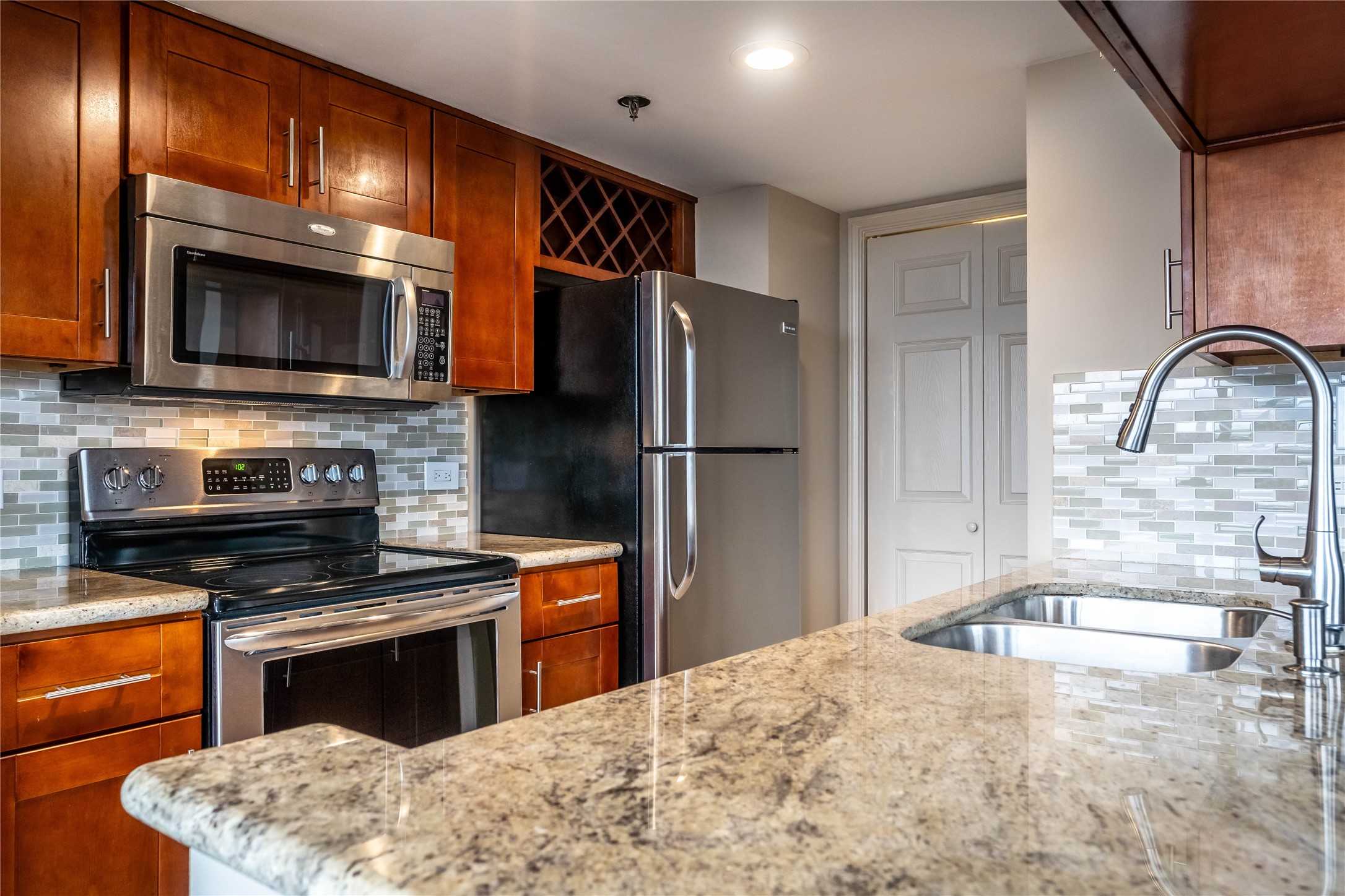 3525 Sage Road, Unit 1009 Houston, TX 77056 - Photo 7 of 23 a kitchen with stainless steel appliances a stove microwave and sink