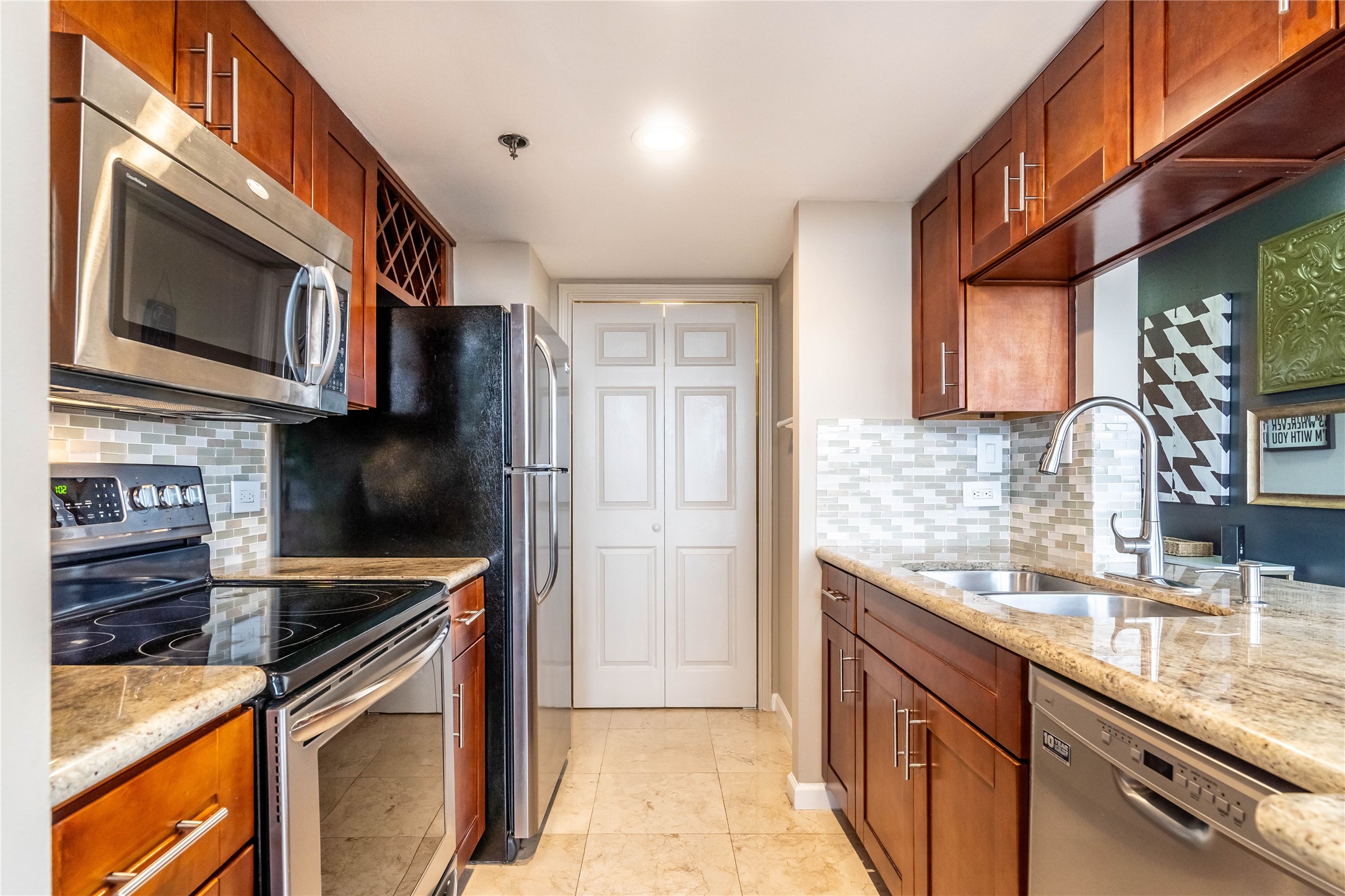 3525 Sage Road, Unit 1009 Houston, TX 77056 - Photo 8 of 23 a kitchen with stainless steel appliances granite countertop a sink stove and refrigerator