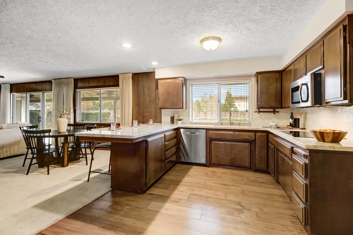 2964 Marco Way Carmichael, CA 95608 - Photo 15 of 49 a open kitchen with stainless steel appliances granite countertop a stove a sink dishwasher a microwave oven and a dining table with wooden floor