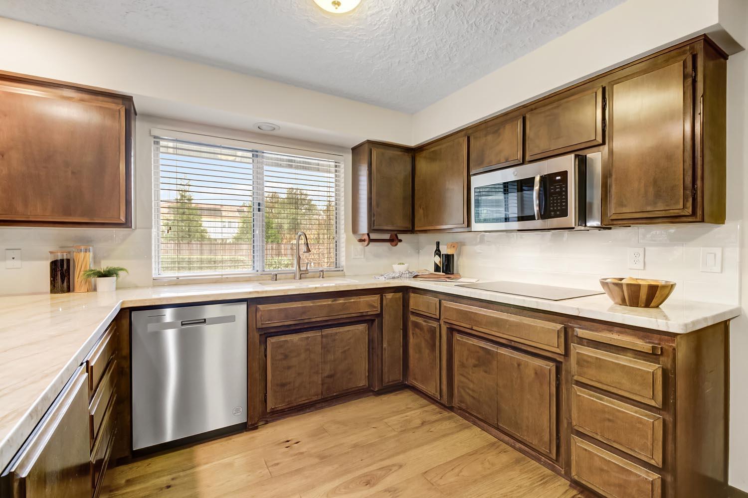 2964 Marco Way Carmichael, CA 95608 - Photo 16 of 49 a kitchen with stainless steel appliances granite countertop wooden cabinets a sink and dishwasher a stove top oven with wooden floor