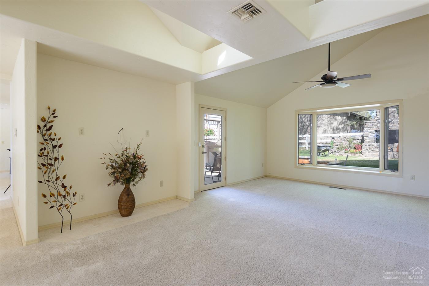 63050 Dickey Road Bend, OR 97701 - Photo 22 of 25 an empty room with windows and chandelier