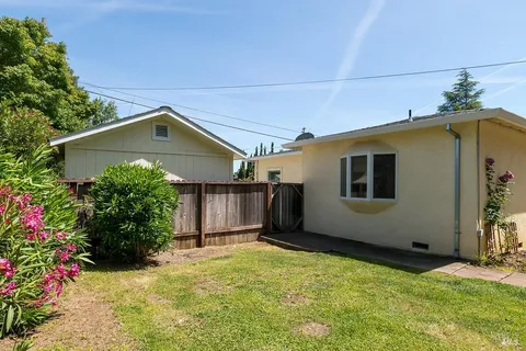 a front view of a house with a yard and potted plants