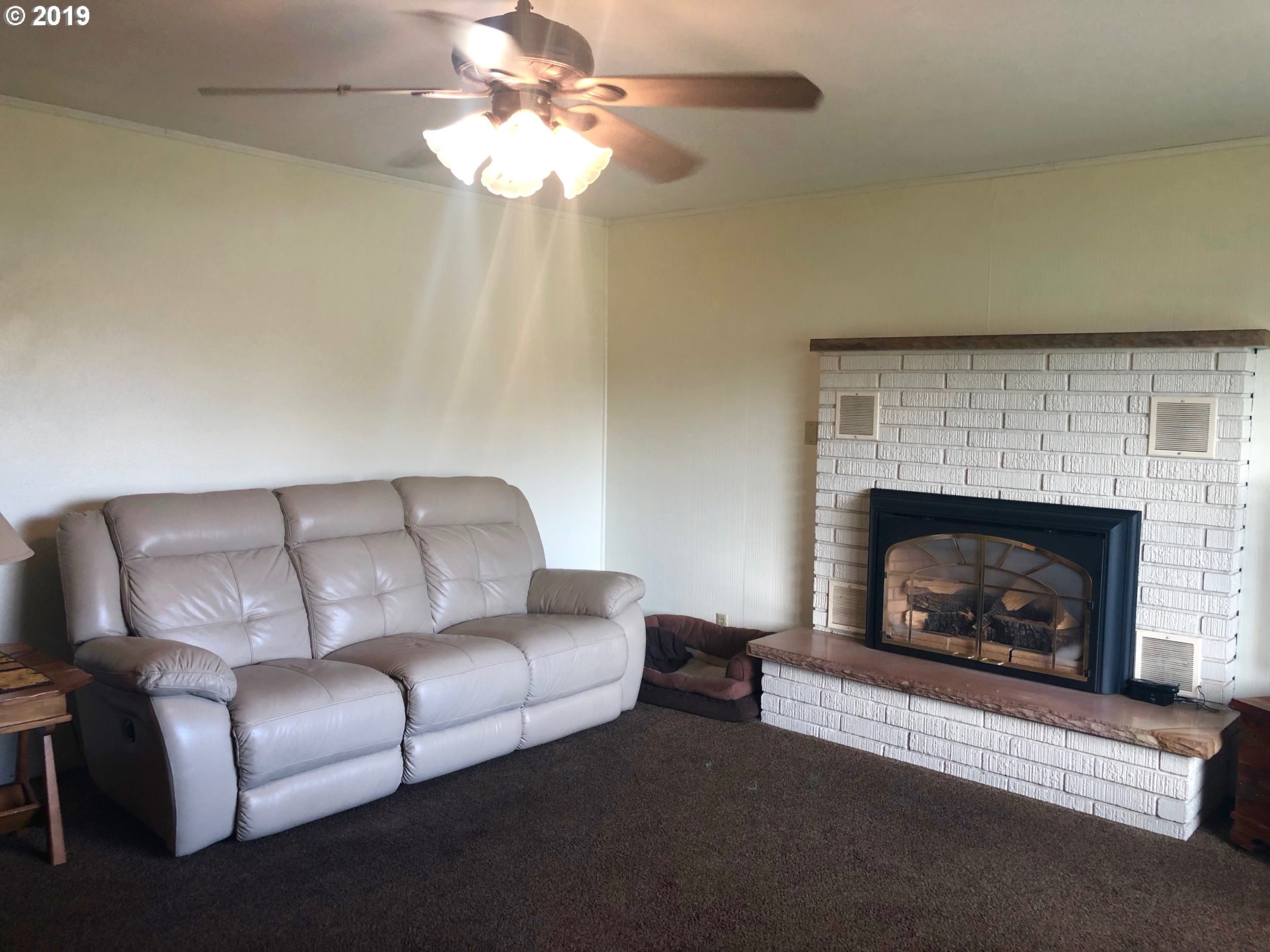 1313 Southwest 39th Street Pendleton, OR 97801 - Photo 3 of 20 a living room with furniture a fireplace and a chandelier