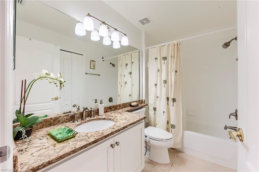 9241 Spring Run Boulevard, Unit 2202 Estero, FL 34135 - Photo 18 of 33 a bathroom with a granite countertop sink a toilet and a large mirror