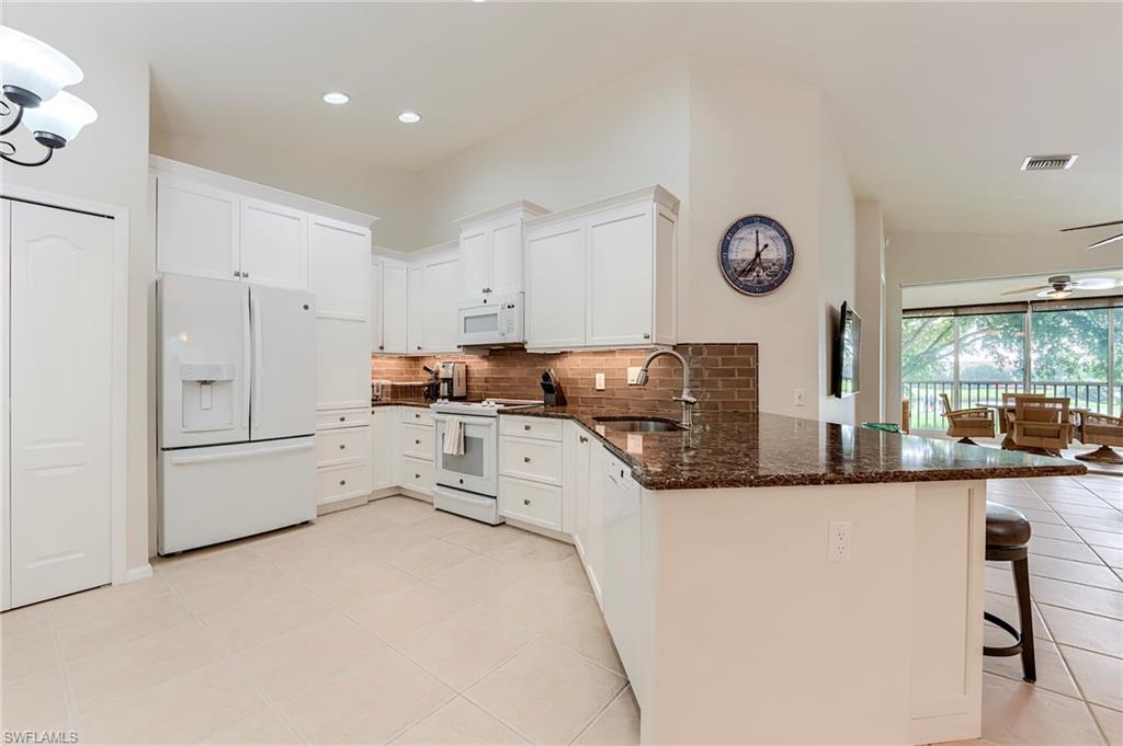 9241 Spring Run Boulevard, Unit 2202 Estero, FL 34135 - Photo 3 of 33 a kitchen with stainless steel appliances granite countertop a refrigerator and a stove top oven