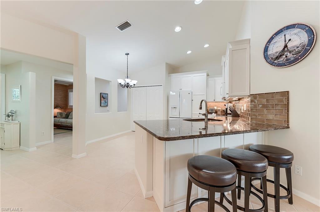 9241 Spring Run Boulevard, Unit 2202 Estero, FL 34135 - Photo 5 of 33 a view of a kitchen with granite countertop a table and chairs