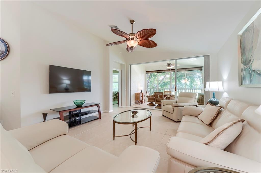 9241 Spring Run Boulevard, Unit 2202 Estero, FL 34135 - Photo 6 of 33 a living room with furniture a chandelier and a large window