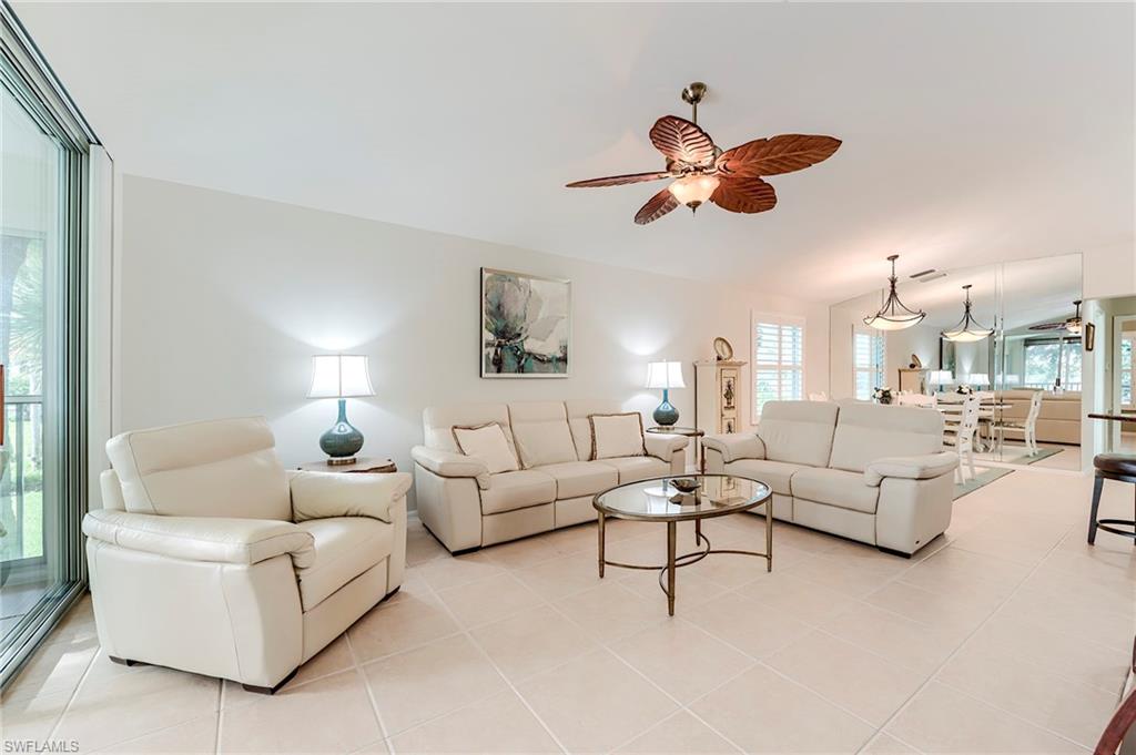 9241 Spring Run Boulevard, Unit 2202 Estero, FL 34135 - Photo 8 of 33 a living room with couches a fireplace and a chandelier