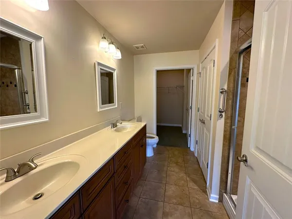 a spacious bathroom with a double vanity sink a mirror and a bathtub