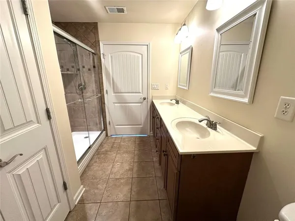 a bathroom with a sink a mirror a vanity and a shower