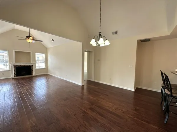 a view of a livingroom with wooden floor and a chandelier