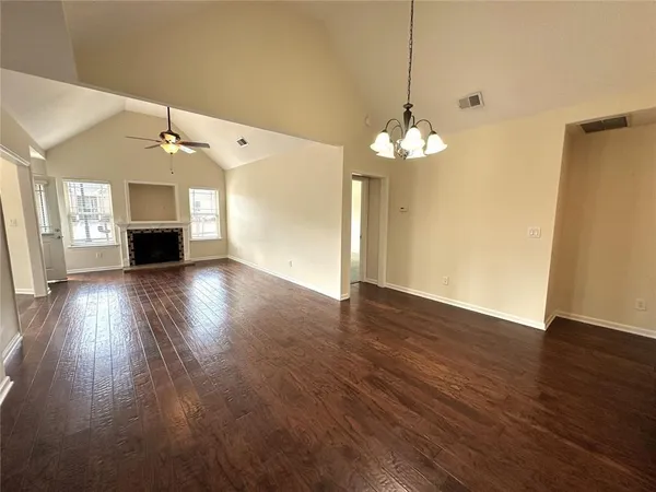 a view of a room with wooden floor and chandelier
