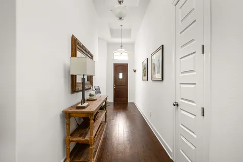 a view of a hallway with workspace and wooden floor