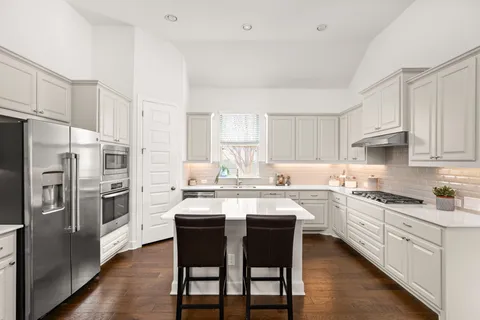 a kitchen with white cabinets and stainless steel appliances