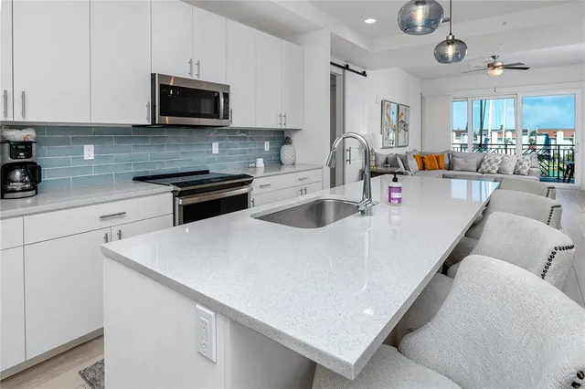 a kitchen with kitchen island a sink appliances and cabinets