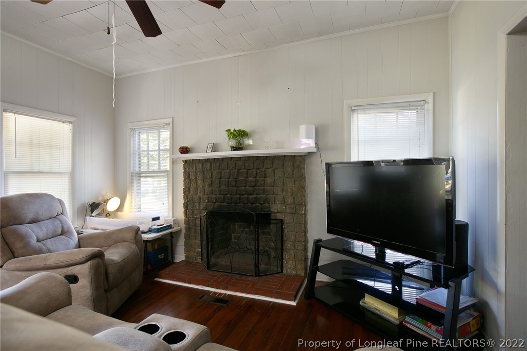117 Ruth Street Fayetteville, NC 28305 - Photo 11 of 27 a living room with furniture a flat screen tv and a fireplace