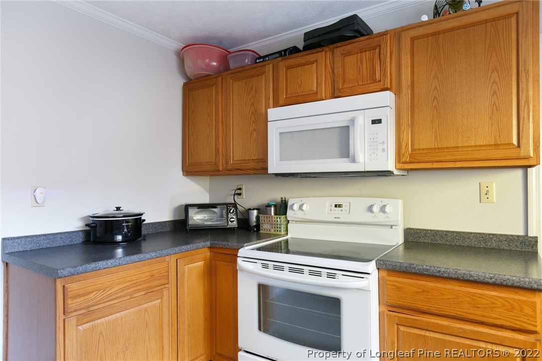 117 Ruth Street Fayetteville, NC 28305 - Photo 12 of 27 a kitchen with stainless steel appliances granite countertop a sink a stove and a microwave oven with cabinets