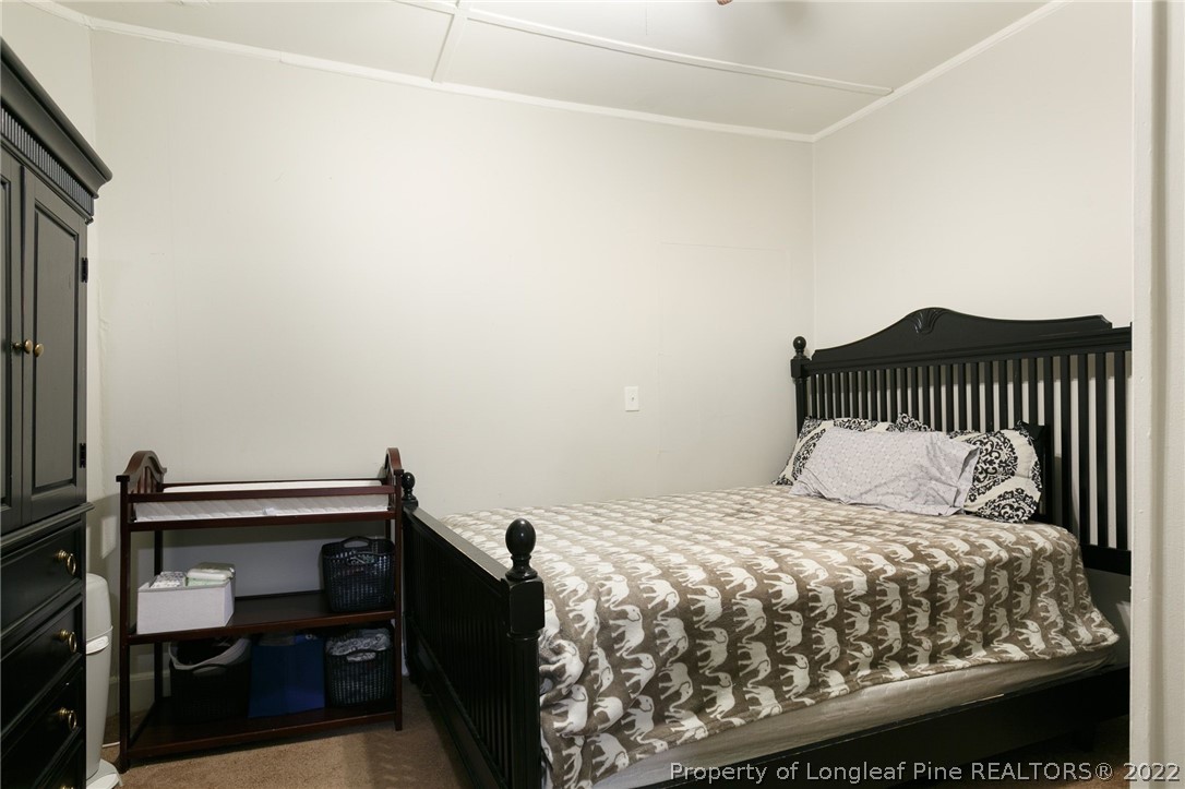 117 Ruth Street Fayetteville, NC 28305 - Photo 25 of 27 a bedroom with a bed and wooden floor