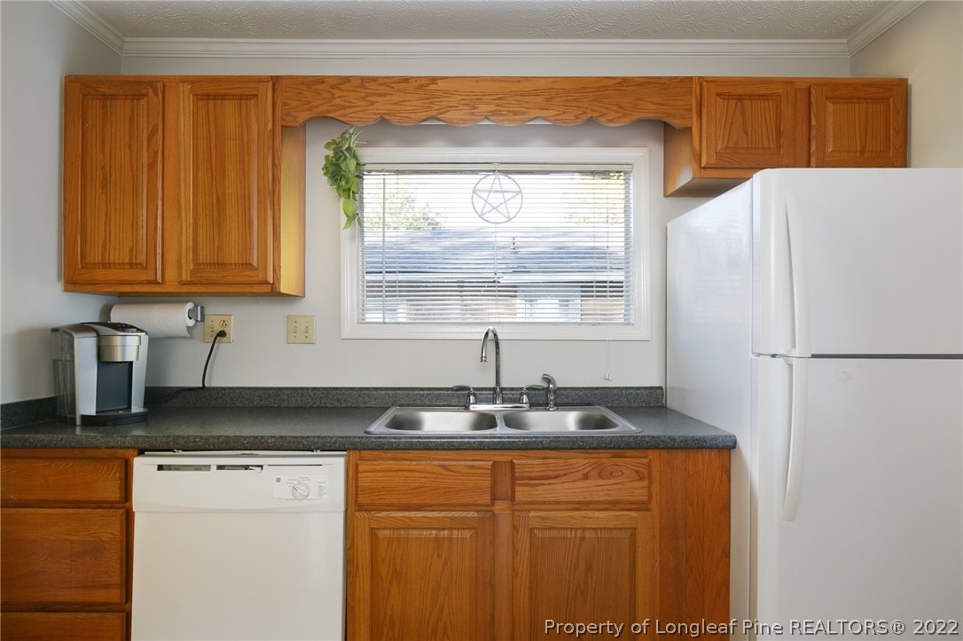 117 Ruth Street Fayetteville, NC 28305 - Photo 10 of 27 a kitchen with granite countertop a refrigerator and a sink