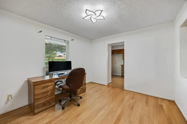 a view of a workspace with furniture and a window