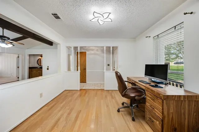 a view of a workspace with furniture and a window