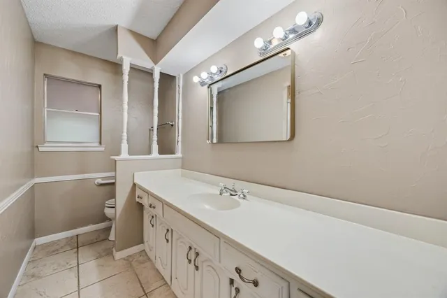 a bathroom with a sink a toilet and mirror