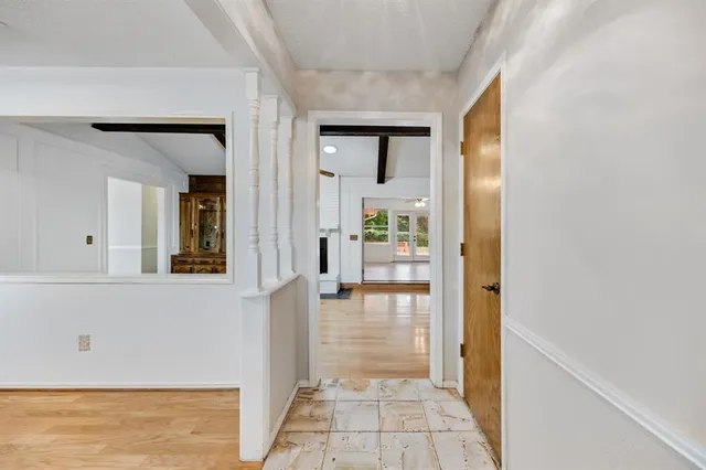 a view of a hallway with wooden floor and a living room