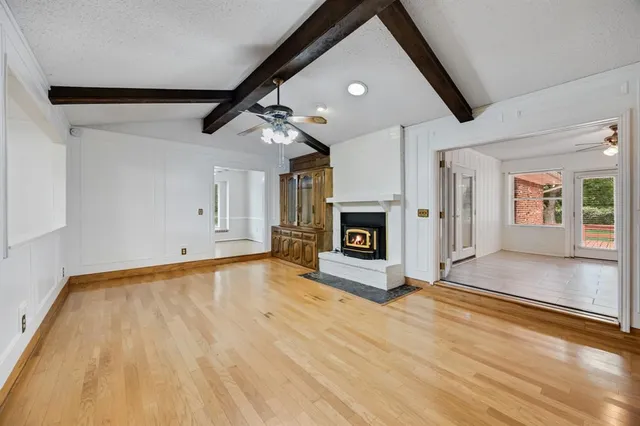 a view of empty room with wooden floor and fireplace
