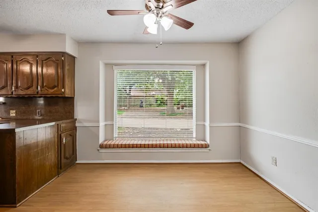 a view of an empty room with a fireplace and a window