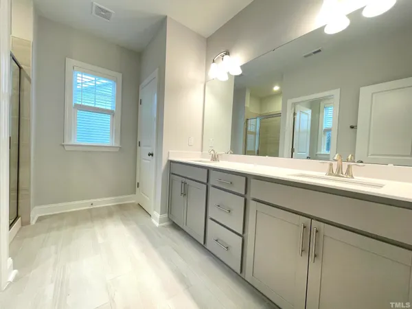 a spacious bathroom with a double vanity sink and a mirror
