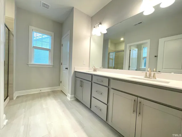 a spacious bathroom with a double vanity sink and a mirror