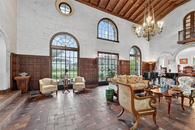 a living room with furniture a chandelier and a dining room