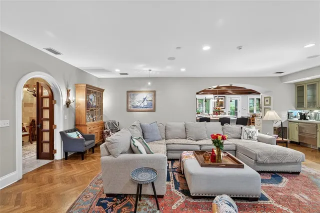 a dining hall with stainless steel appliances kitchen island granite countertop a table and chairs in it