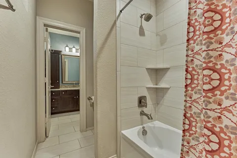 a bathroom with a tub sink and mirror
