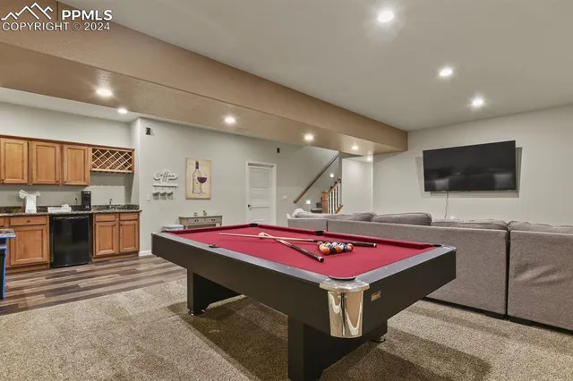 a room with pool table flat screen tv and windows