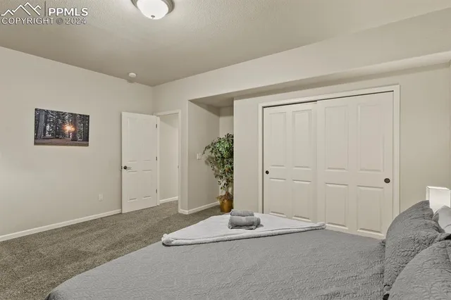a bedroom with a bed and a potted plant